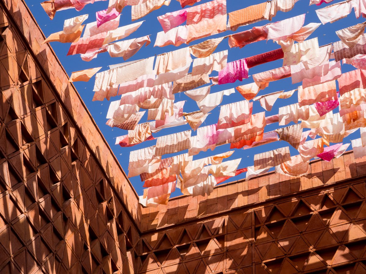 Pinkish clothes hanging across top of patio against blue sky