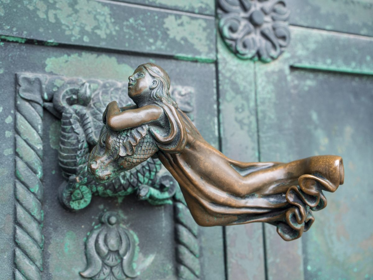Bronze door handle of girl holding dragon