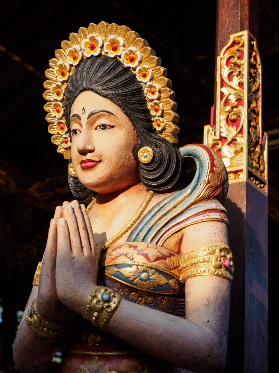Wooden carved and painted pillar of praying woman