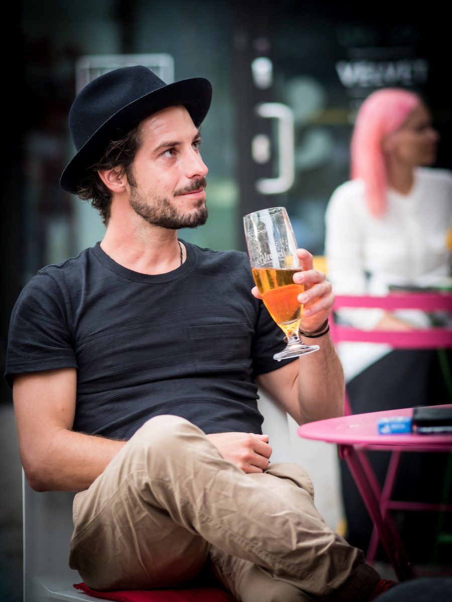 Man in hat drinking beer in cafe