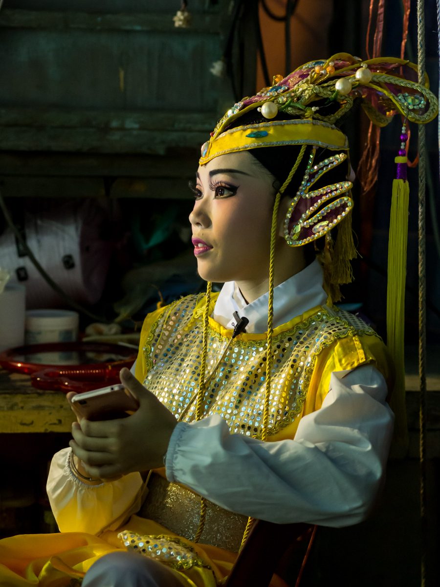 Chinese opera performer with cell phone