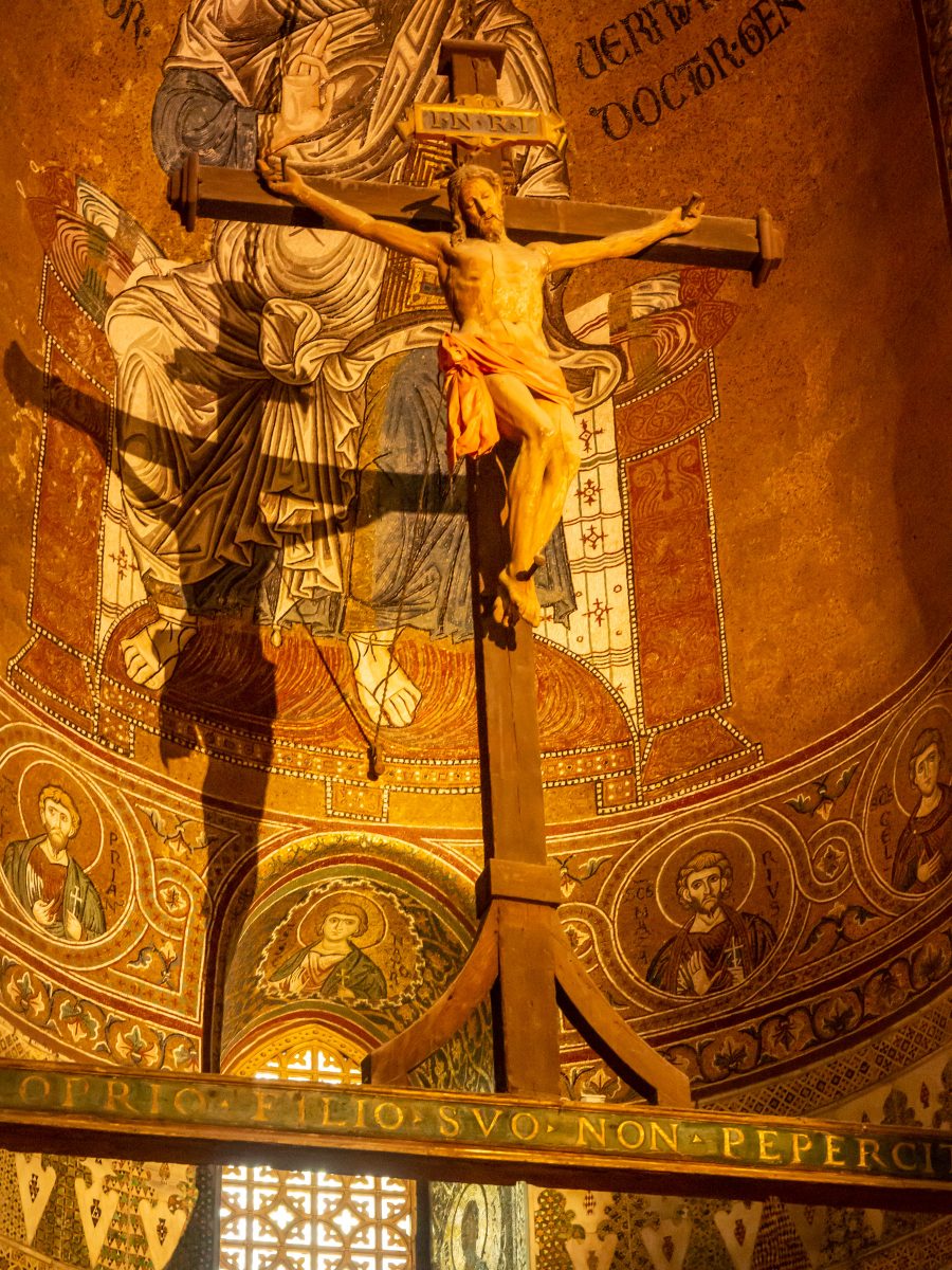 Large wooden crucifix in front of Byzantine tile mosaics