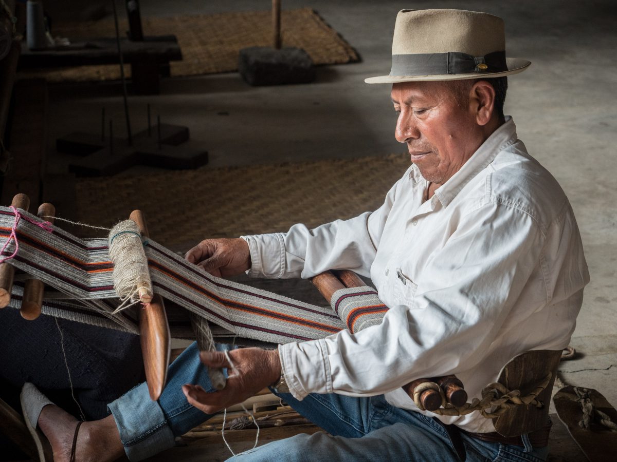 Man weaving with backstrap loom