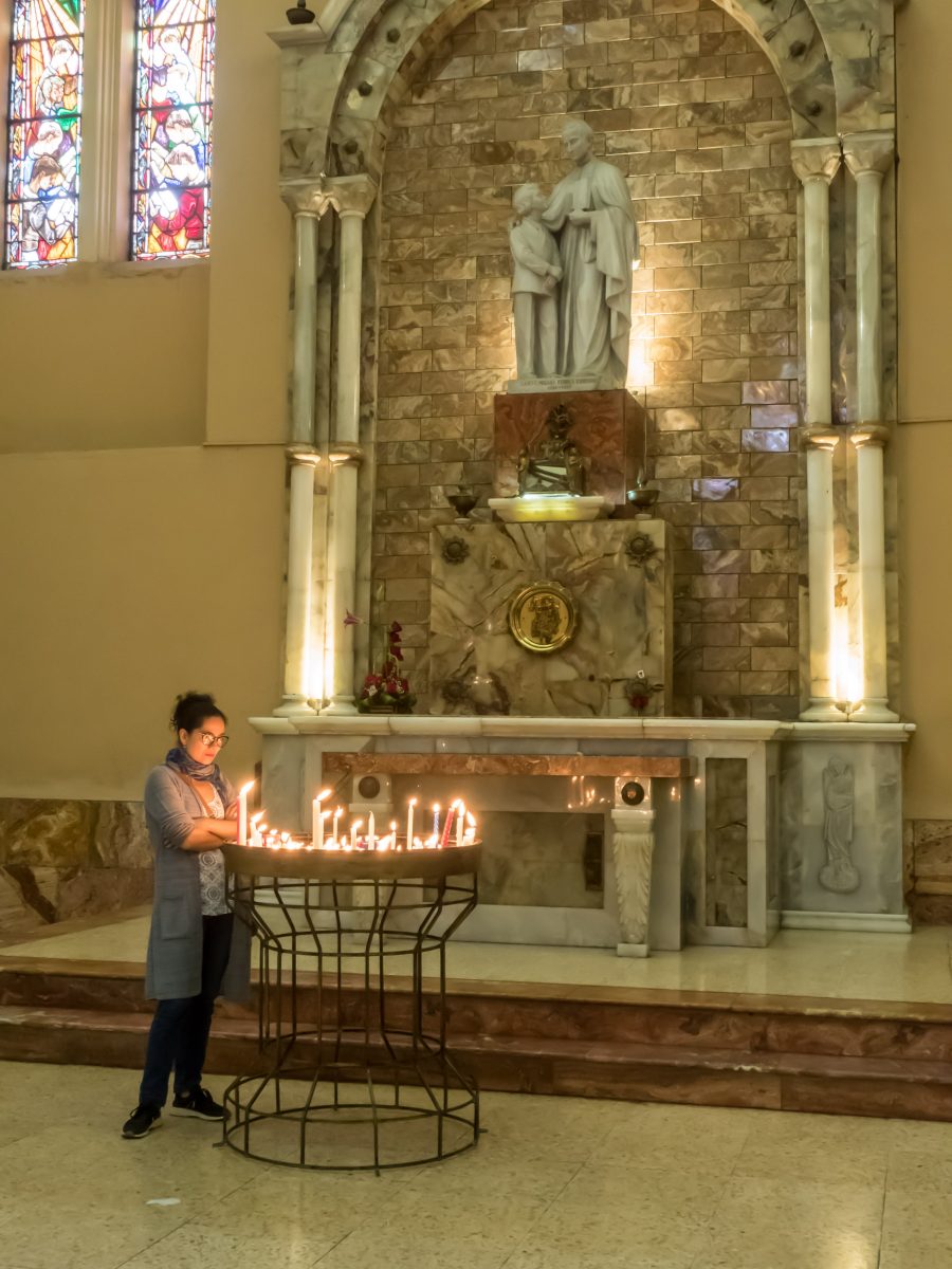 Woman lighting candle at church alter